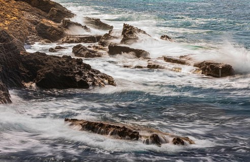 Rugged rocky coastline and foaming spray, on Stecci beach, near Capoliveri, Elba Island, Tuscan