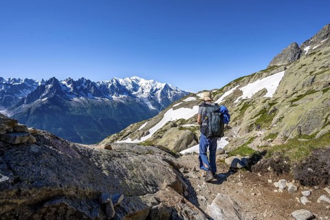 Mountaineer on hiking trail, mountain panorama with glaciated mountain peaks, Aiguille du Midi and