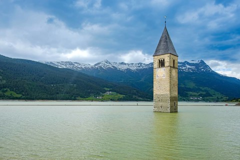 Bell tower of the former parish church of St Catherine in the sunken village of Alt-Graun in Lake