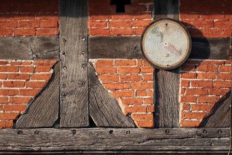 An old target hangs on the outside wall of a farmhouse, half-timbered, historical, Böhme,