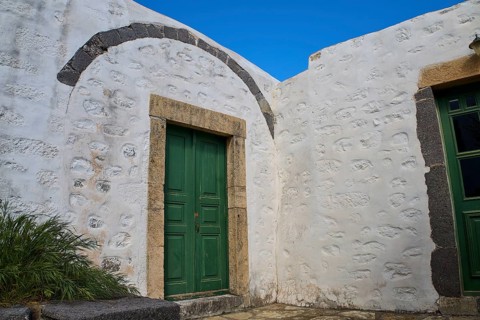 Green wooden door in a thick, whitewashed wall under a blue sky, Monastery of the Revelation, Moni