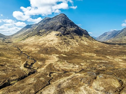 Buachaille Etive Beag and Three Sisters in Glencoe over Moors and Road A82 from a drone, Highlands,