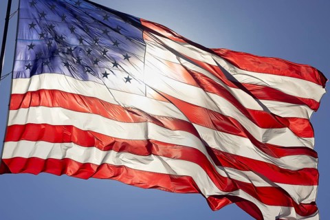 Dramatic backlit american flag waving in the wind