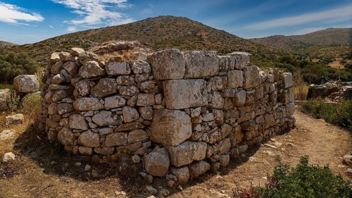 Sky exchanged, Large stone wall in an unspoilt mountain landscape with cloudy sky and surrounded by