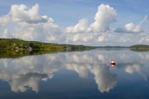 View over the Möhnesee, Möhnesee tower, red and white buoy, blue cloudy sky, reflection on the