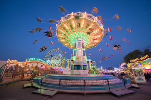 Colourful carousel with light show at a funfair at night, chain carousel, spring festival,