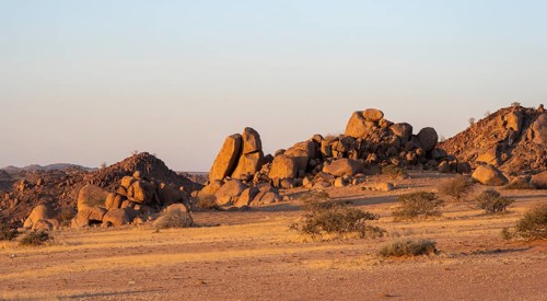 Barren landscape with hills of stacked rocks, desert landscape in the evening light at sunset,
