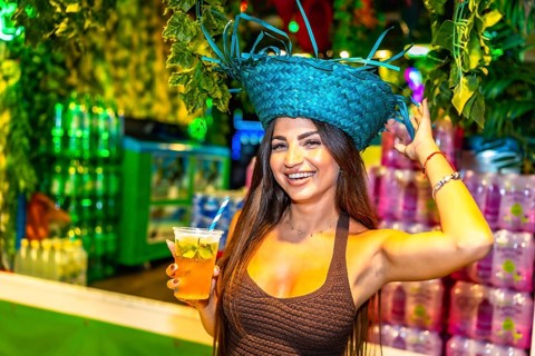 Beautiful young woman enjoying a refreshing cocktail at a vibrant brazilian carnival celebration,