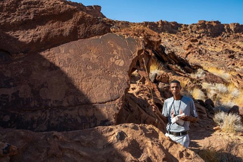 Tourist guide explains the details of the rock engravings at Twyfelfontein, Twyfelfontein, Kunene,