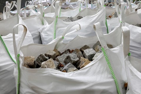 Building site, road construction, granite paving stones packed in big packs, cobblestones