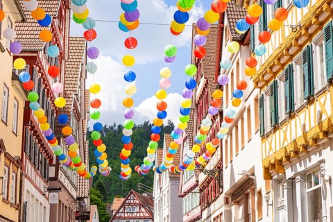 Colourful balloons decorate a narrow street in a picturesque old town under a sunny sky, Calw,