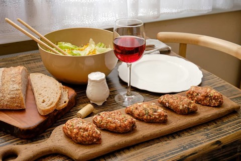 A cozy dining setup features savory meat patties served on a wooden board alongside a fresh salad