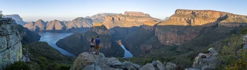 Two hikers enjoying the panorama, sunset at Blyde River Canyon with Three Rondawels peak, view of