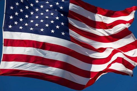 American flag waving in the wind against deep blue sky