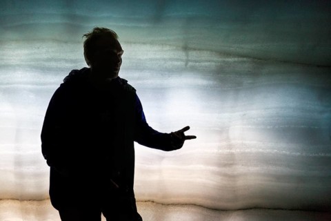 Guided tour through ice tunnel, glacier cave, tourist guide explains, backlight, glacier tour,