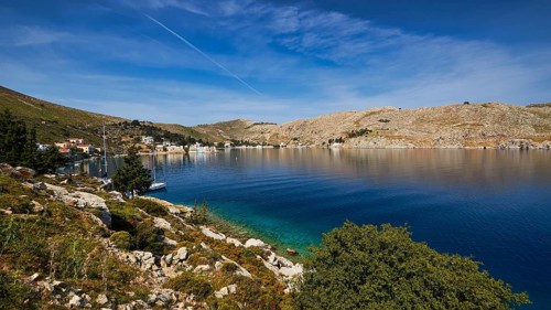 Coast with blue water and hilly landscape under a clear sky, Bay of Emporio, Emporio, Symi,