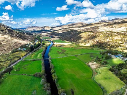 Farms and Mountains over River Dochart and Road A85 from a drone, Perthshire, Scotland, UK