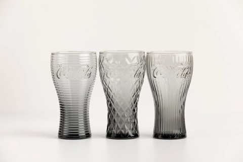 Three stylish, differently designed cola glasses in transparent and black tones
