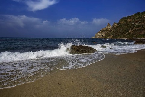 Sea crashing against rocks on the beach under a clear blue sky, Ricadi, Capo Vaticano