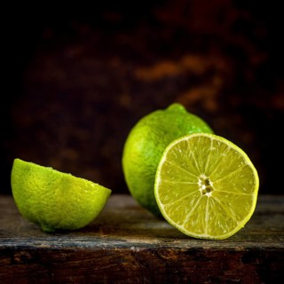 Close-up view of fresh lemons and their slices set against a brown background, showcasing the