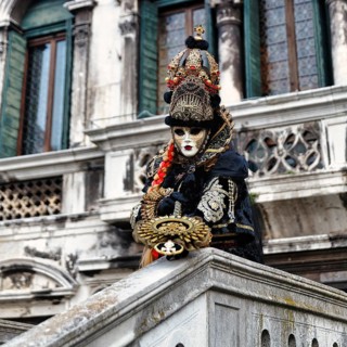 Venetian costume with mask, disguised person posing, carnival in Venice, Italy
