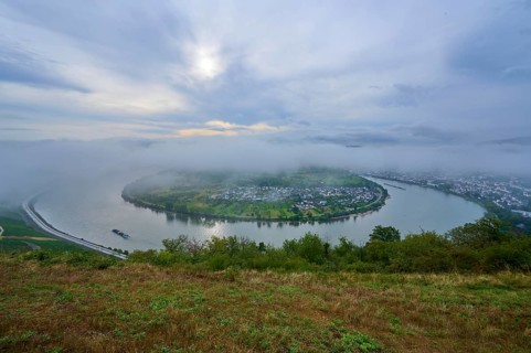 Foggy river bend, surrounded by green hills and calm morning atmosphere, summer, Rhine bend