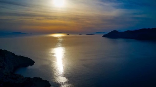 Drone shot, Fascinating sunset with light reflection in the water, Holy Week, Bay of Panormitis,