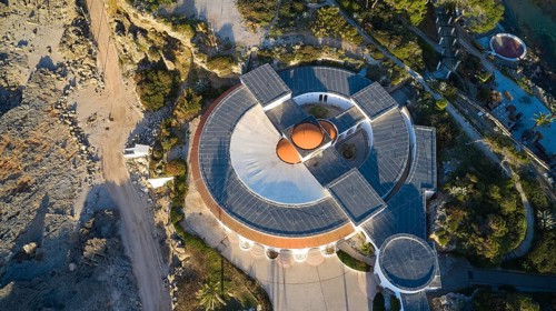 Drone shot, morning light, building from above with modern architectural elements and circular