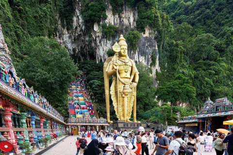 Murugan statue the God of War and colorful staircase leading to the caves with many pilgrims, Batu
