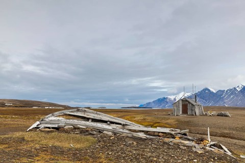Broken wooden boat in front of hunting hut, wooden hut, Bamsebu, Spitsbergen, Svalbard