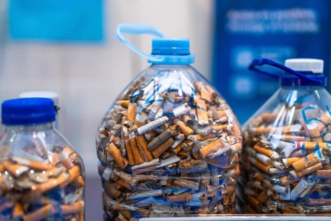 Plastic bottles filled with cigarette butts highlighting environmental pollution and the need for