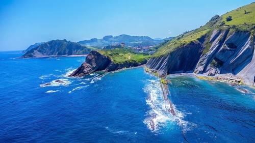 Breathtaking aerial view of the unique flysch cliffs meeting the deep blue water of the cantabrian