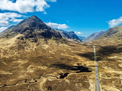 Buachaille Etive Beag and Three Sisters in Glencoe over Moors and Road A82 from a drone, Highlands,