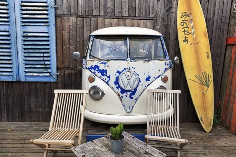 Original terrace, front of VW bus T1, Bulli, vintage car, wooden facade with surfboard as