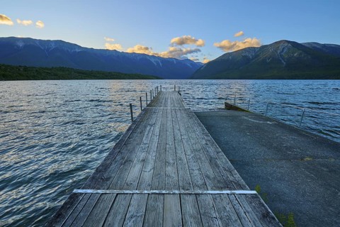 Wooden jetty at the lake with mountains at dusk and clouds, summer, Lake Rotoiti, Saint Arnaud,