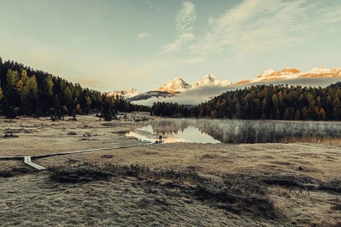 Lake Staz near Sankt Moritz in the Engadin in Switzerland. Morning atmosphere with fog in autumn.