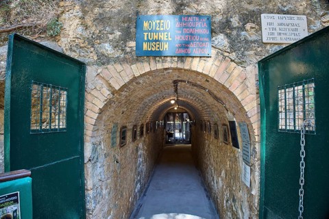 Entrance to a tunnel museum with green doors and several signs, War Museum, Military Museum, Tunnel