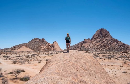 Tourist with camera, rock formation, Pontok Mountains, Spitzkoppe, Große Spitzkuppe Nature Reserve,