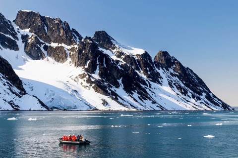 Zodiac in front of mountains with snow, sea, Smeerenburg, Spitsbergen, Svalbard