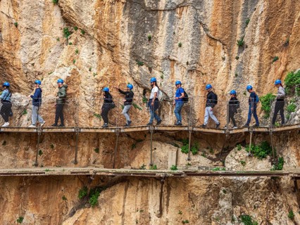Tourists on the elevated path of the caminito del rey, along a deep gorge, Andalusia, Spain