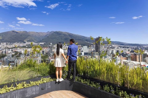 Quito, Ecuador, May 2 2025: Young tourist couple overview Carolina Park modern condominiums in