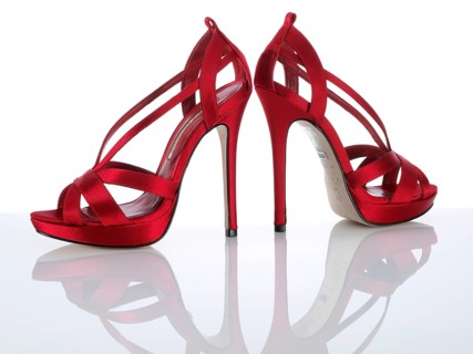 A pair of red ladies pumps, high heels, in front of a white background, studio shot