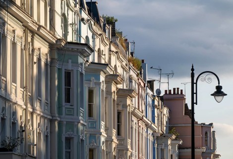 Street lamp, terraced houses, townhouses with different, partly pastel-coloured facades Portobello