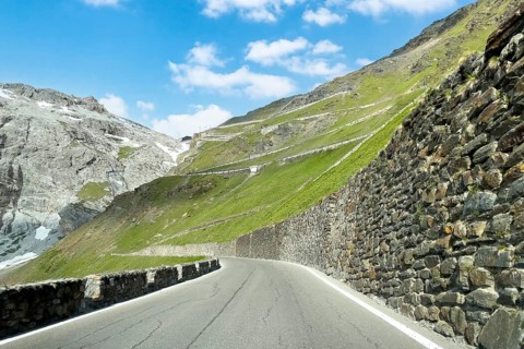 View of east ramp ascent to descent from Alpine pass Stelvio Stilfserjoch mountain road above tree