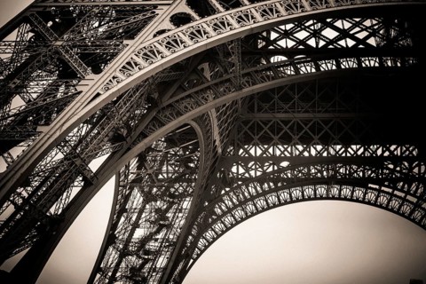 Beneath the iconic Eiffel Tower, the stunning architectural design is highlighted against a gray