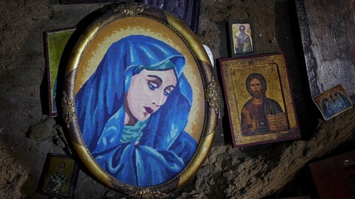 Portrait of Mary in blue in an oval frame, surrounded by smaller icons and religious depictions,