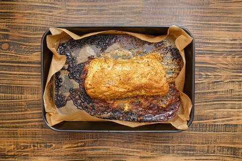 Overhead view of roasted pork neck in a baking tray