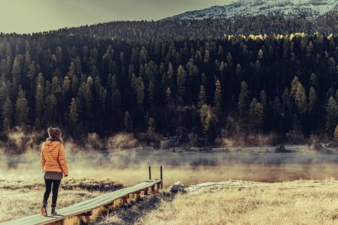 Young woman at Lake Staz near Sankt Moritz in the Engadine in Switzerland. Morning atmosphere with