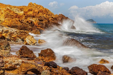 Rugged rocks and foaming spray on Topinetti beach, near Rio Marina, Elba Island, Tuscan Archipelago