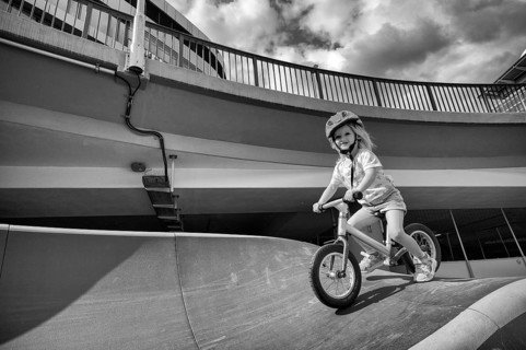 Girl, blonde, 3 years, laughing, riding with bicycle, bike, crash helmet, subway, urban, concrete,